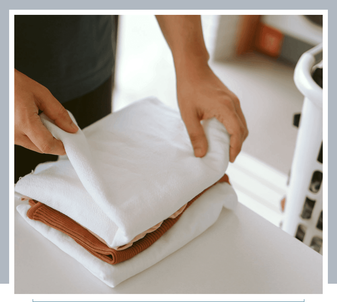 Person folding clothes on a table.