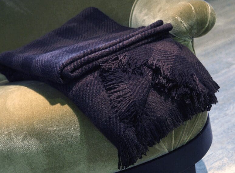 Dark blanket draped over green chair.