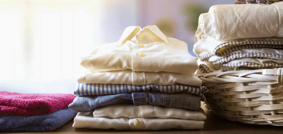 Folded clothes and towels on a table.
