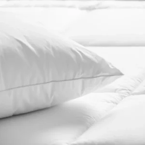 White pillow on a quilted bed.